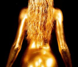 Glamorous woman covered in gold body paint with long, wet hair, showcasing artistic body art and photography skills. Glamorous woman covered in gold body paint with long, wet hair, showcasing artistic body art and photography skills.